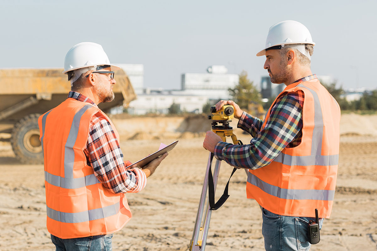 Two construction workers surveying a site